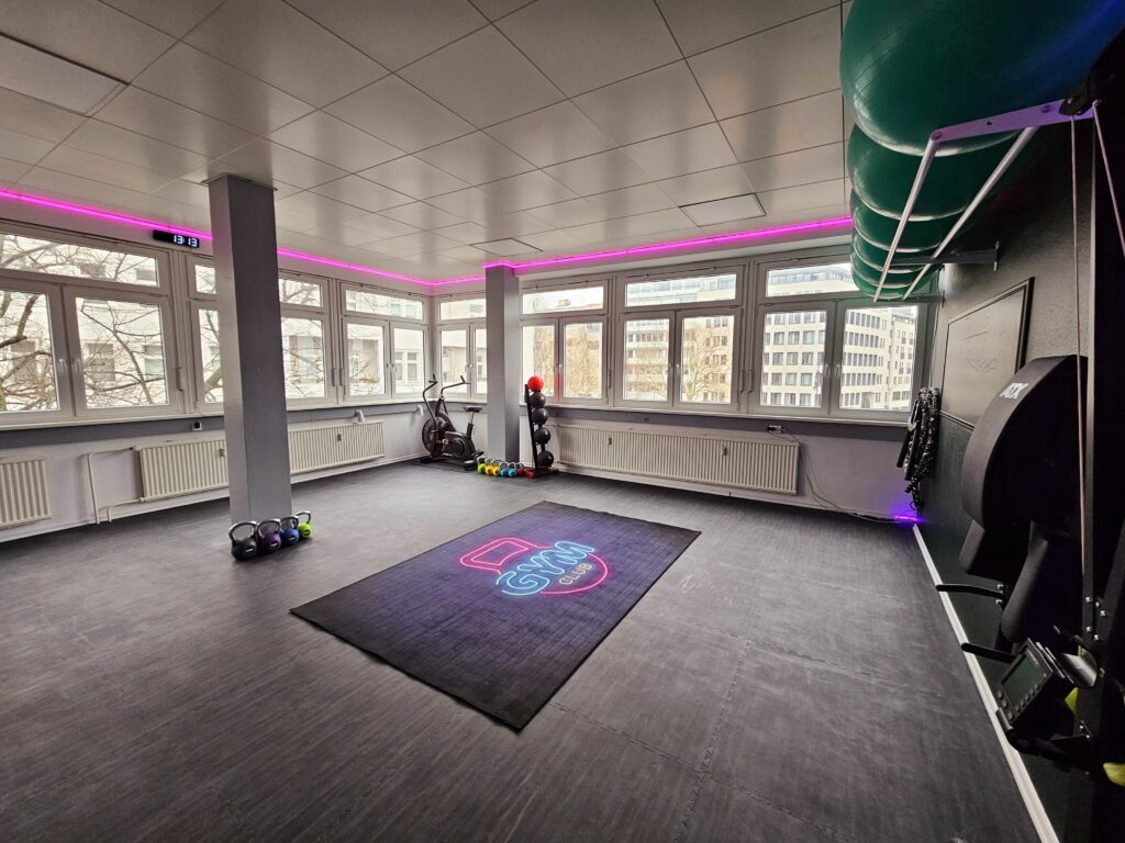 Kursraum der Therapiepraxis Tom Gundlach in Berlin mit Trainingsfläche, Kettlebells und Gymnastikbällen